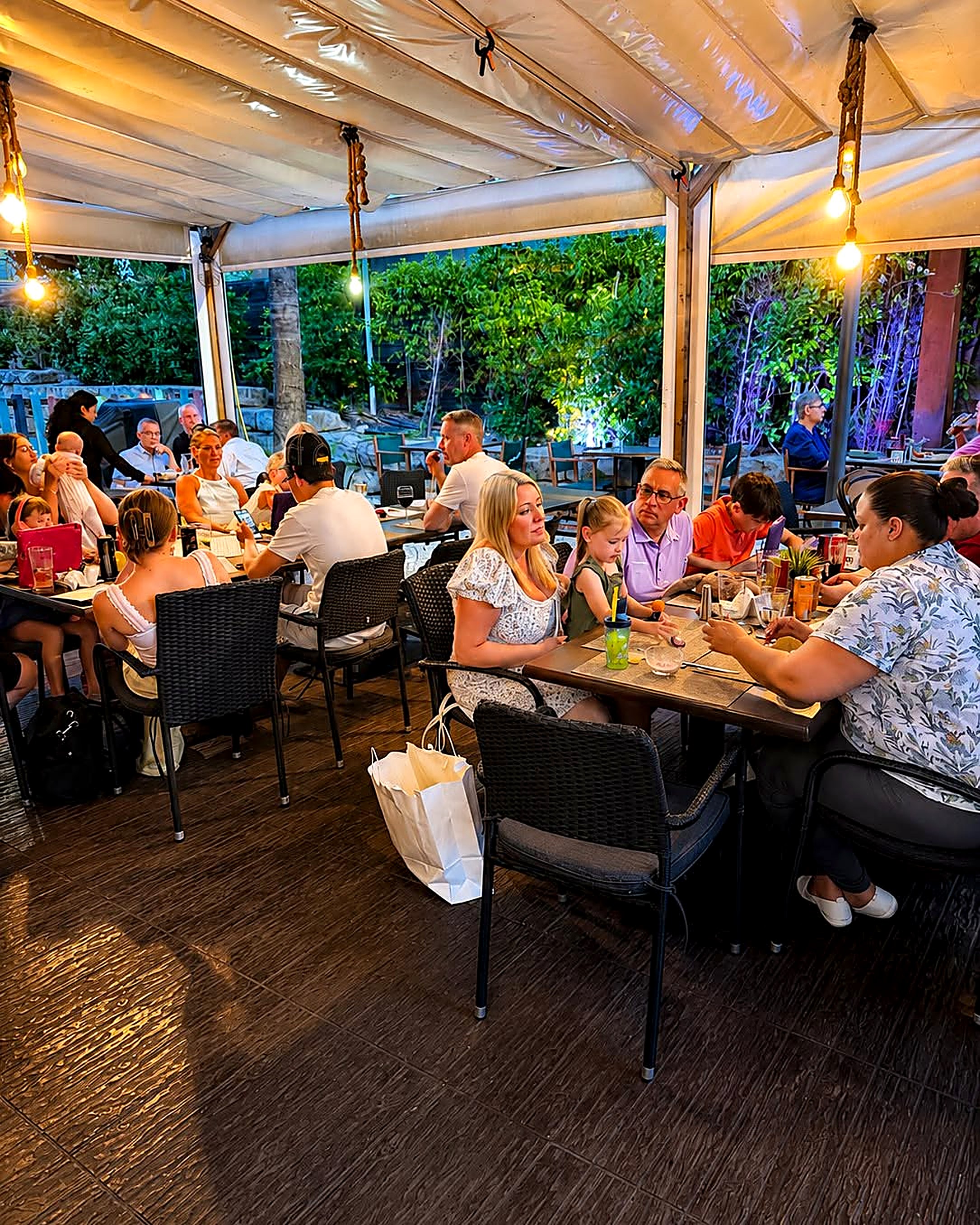 Friends dining on the Oscars terrace at dusk